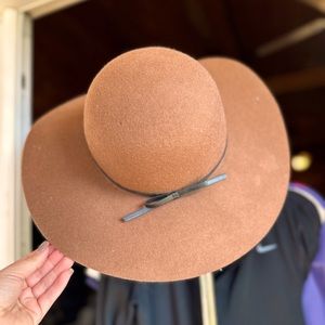Brown hat with black leather bow wrapped around the base